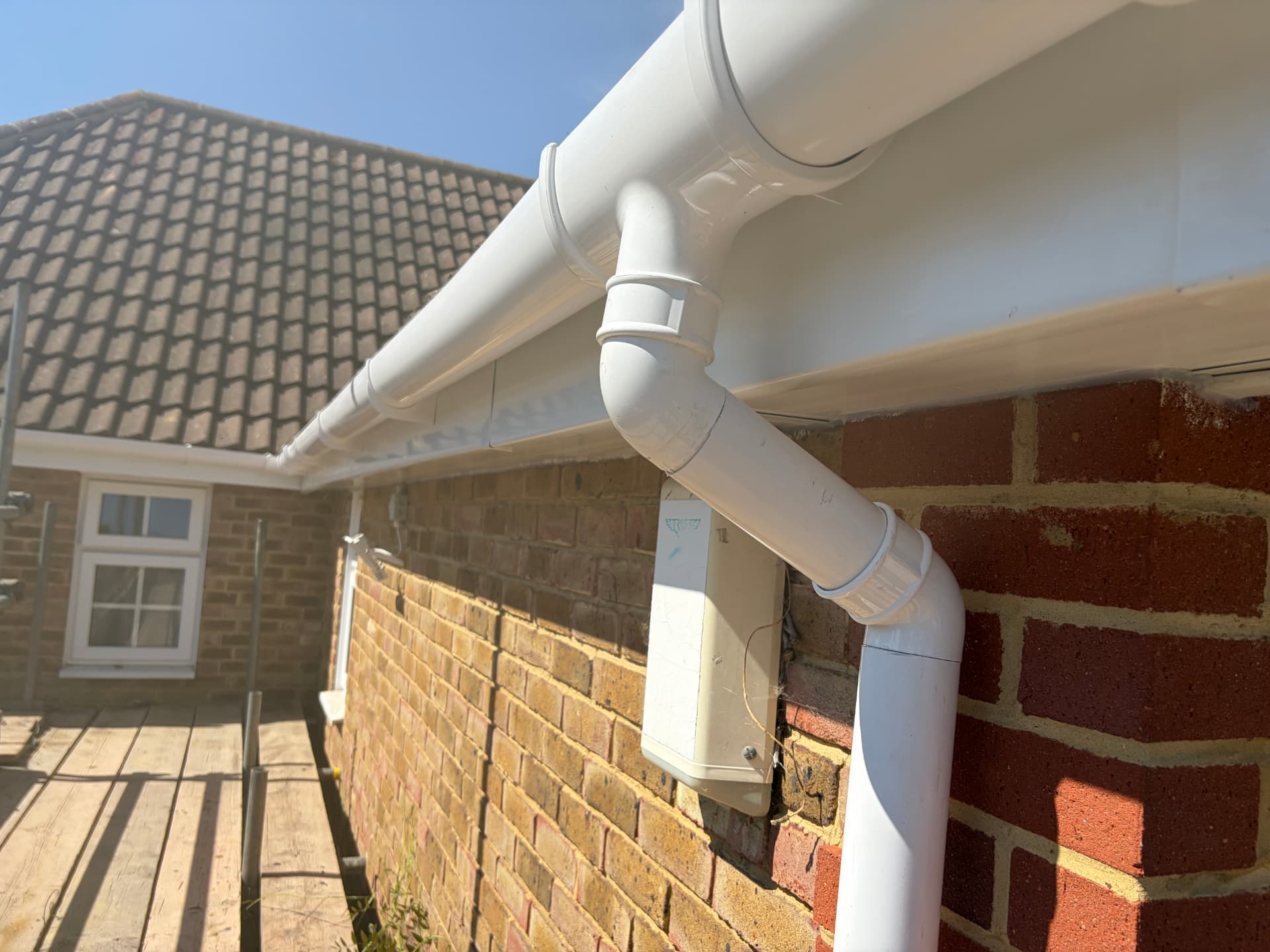 New white fascia, soffit and deep flow guttering with downpipe fitted over scaffold on the Bracknell property